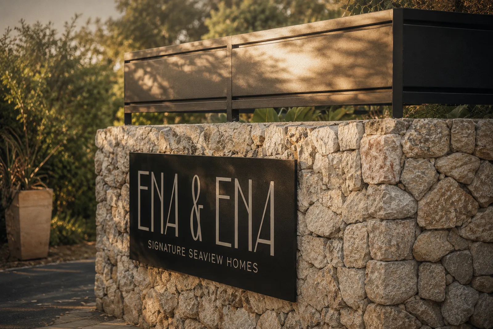 The finished Ena & Ena sign on the stone entrance wall at golden hour